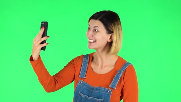 Smiling Girl Talking for Video Chat Using Mobile Phone. Green Screen