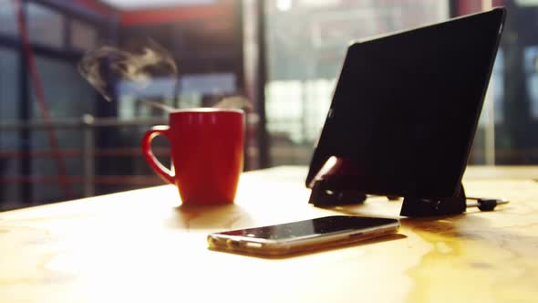 Digital tablet, mobile phone and cup of coffee on desk