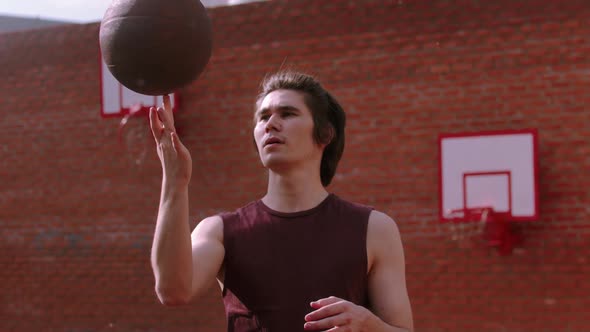 Young Man Spinning Basketball Ball on the Finger