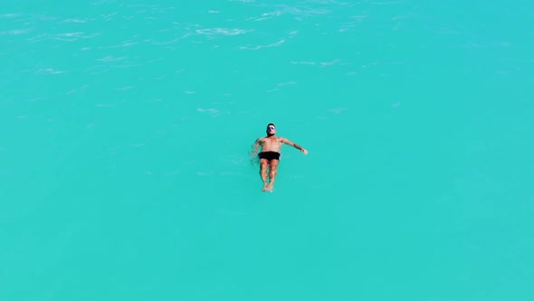 A Young Male Model Swimming Alone In the Turquoise Caribbean Sea In Slow-Motion