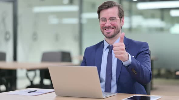 Thumbs Up By Positive Young Businessman Working 