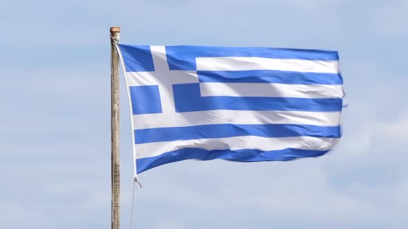 Greek flag fluttering on sunny and windy day. Slow tilt up
