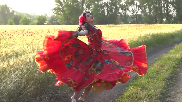 Gypsy girl in a field of poppies dancing in slow motion.