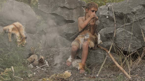Caveman Manly Boy Making Primitive Stone Weapon in Camp
