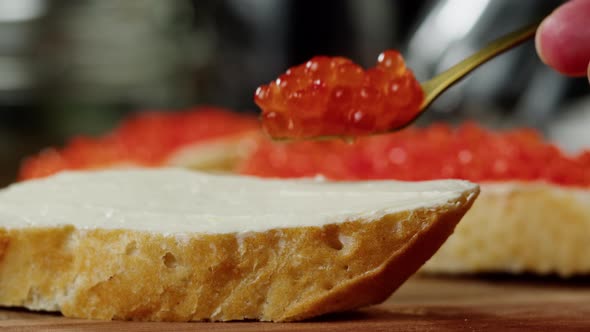 Mixing Red Caviar in Glass Bowl Closeup