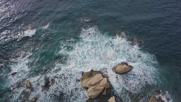 Aerial View of Crashing Waves on Rocks