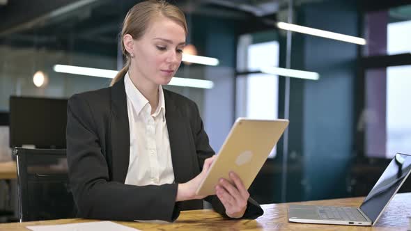 Hardworking Young Businesswoman Using Tablet in Modern Office