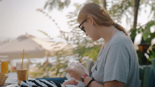 Mother feeding baby from the bottle in outdoor cafe