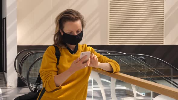 Lonely Woman Wearing Face Mask Using Browsing Pn Her Phone Standing in the Shopping Mall Next To