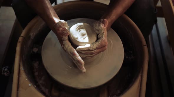 Beautiful Closeup Shot of Wet Male Hands Working with Clay on a Potter's Wheel