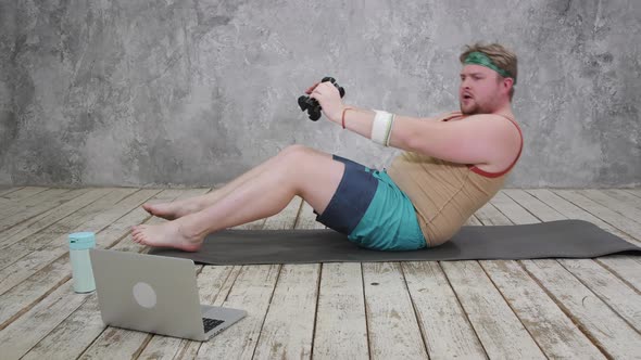 Funny Fat Man in Sportswear Doing Sports Exercises Looking Into a Laptop