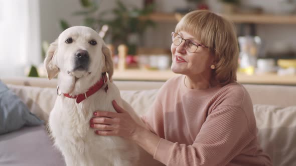 Portrait of Happy Senior woman Petting Dog at Home