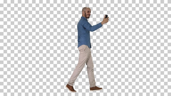 Happy smiling handsome young man making selfie while walking