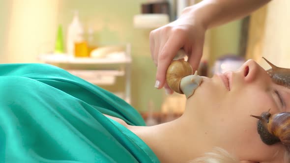 Young Woman Receiving Skin Treatment with Snails Massage