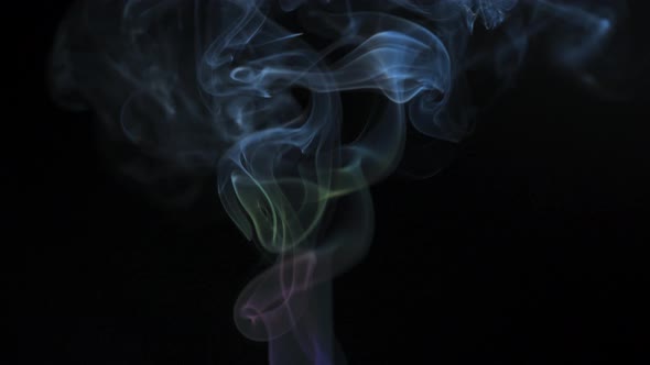 Abstract Colored Smoke Rises Up in Beautiful Swirls on a Black Background