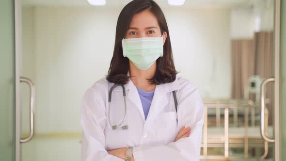 Portrait of Asian female doctor wearing protective surgical mask before complete examination job.