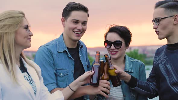 Happy Friends Drinking Beer, Cheering With Bottles And Dancing Outdoors.