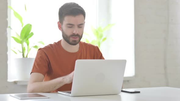 Young Man Coughing at Work in Office