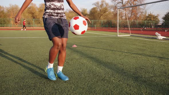 A Nice Young Black Girl in a Soccer Team Training Session Stands Near the Goal and Juggles the Ball