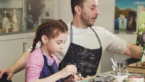 Happy Father Taking Photos of His Cute Little Daughter While She Is Drawing