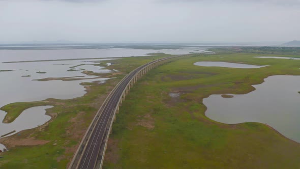 Aerial view of Thai local train on railway bridge at Pa Sak Jolasid Dam, the biggest reservoir