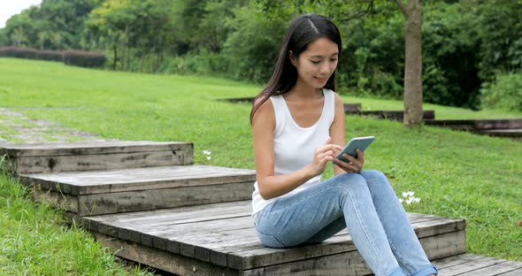 Student using smart phone in city park