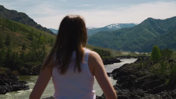 River Runs Across Mountain Valley and Woman on Sunny Day