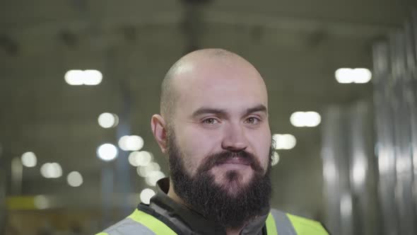 Camera Moving Up, Portrait of Bearded Baldheaded Caucasian Man Smiling at Camera. Happy Worker in