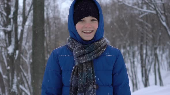 Young Teenage Boy Walks in Winter Forest