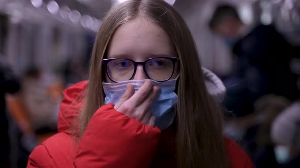 Pretty Teen Girl Pulling Up Mask on Face in Subway