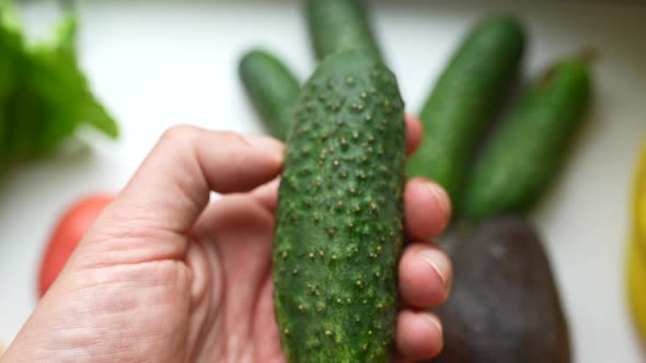 A Man's Hand Holds a Cucumber The Concept of Proper Nutrition