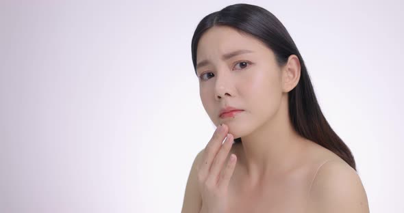 Young Asian Woman Touching Her Face Softly. Feeling Worry About Face Skin Care Problem On Cheek.