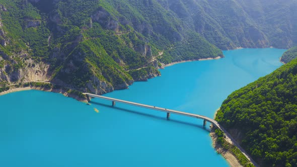 Aerial top view on Bridge over Lake Piva with turquoise water in mountains canyon in Montenegro