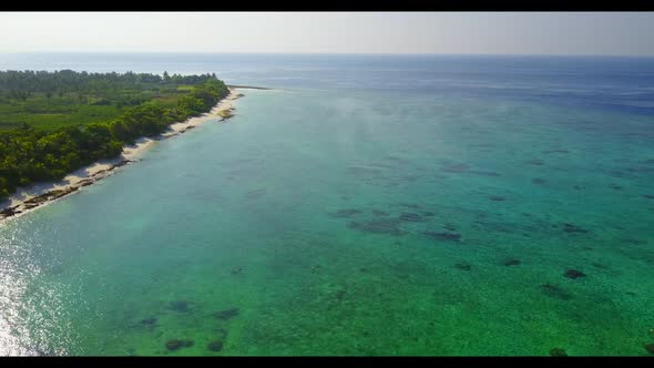 Aerial top view seascape of tranquil island beach holiday by turquoise lagoon with white sandy backg
