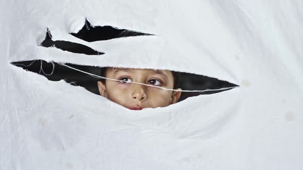 Little Refugee Boy Hiding behind Cloth