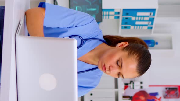 Vertical Video Medical Woman Nurse Holding Patient Radiography Typing on Laptop