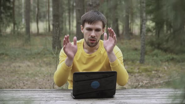 Man is Typing on Laptop in Forest Receives Bad News Upset Despairs