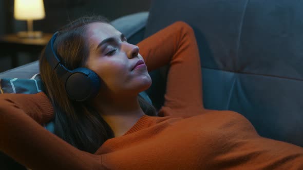 Young Woman is Lying at Home on the Couch with her Eyes Closed