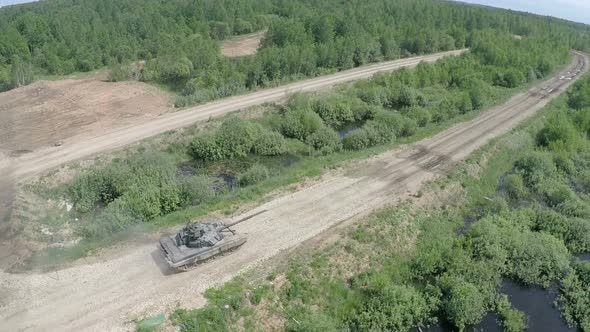 Flying over tank driving on rough ground in the woods