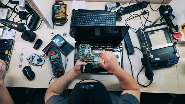 Top View of a Repairman Dismantling a Laptop