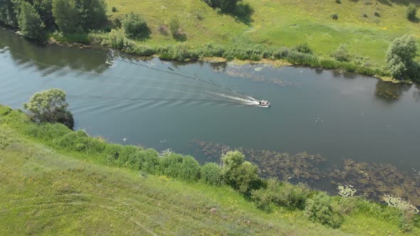 Aerial View. a Small Rubber Fishing Boat with A Motor Is Moving Quickly on A Small River