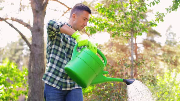 Middle-aged Man Watering Flowers at Garden