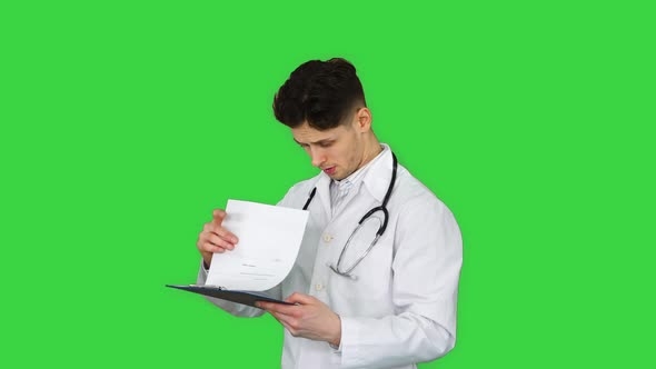 Angry Male Doctor Looking at Documents on a Green Screen, Chroma Key