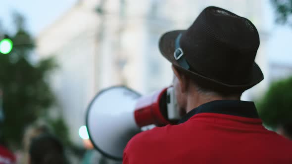 Megaphone Activist Speaks While Marching in Political Picketing Protesters Crowd