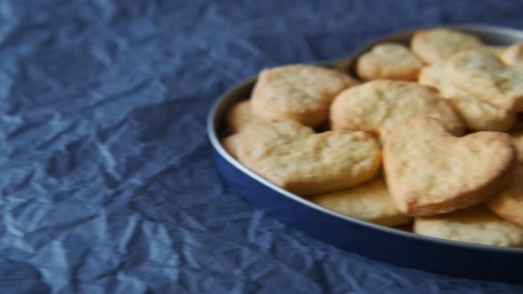 Closeup of Light Brown, Homemade Biscuits in a Metal Tray against Blue Background