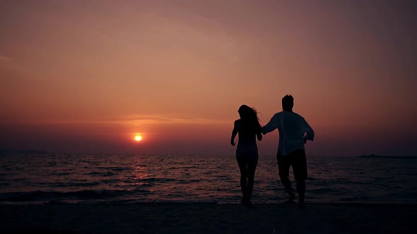 Young People Have Fun on Ocean Beach in Dusk Slow Motion