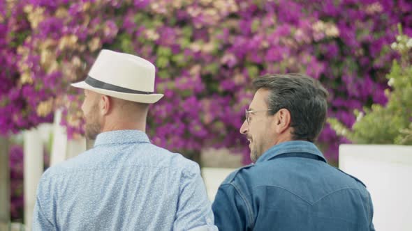 Back View of Homosexual Men Going to Garden with Lilac Trees