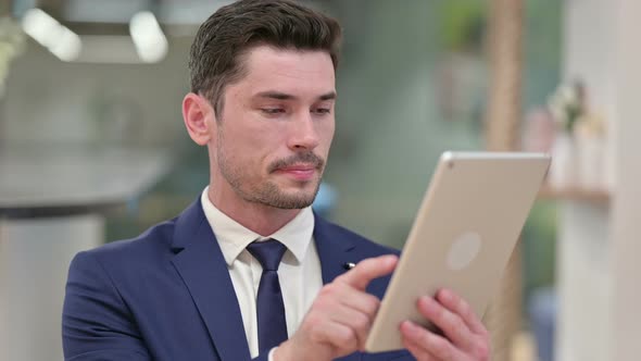 Attractive Young Businessman Using Digital Tablet