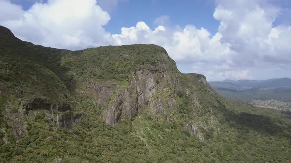 Mountain with Lush Flora Near Small Country Against Sky