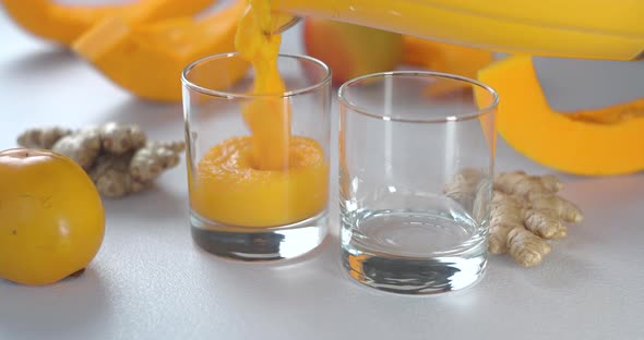 Pumpkin and Ginger Smoothie is Poured Into Glasses Against a Background of Fresh Vegetables and